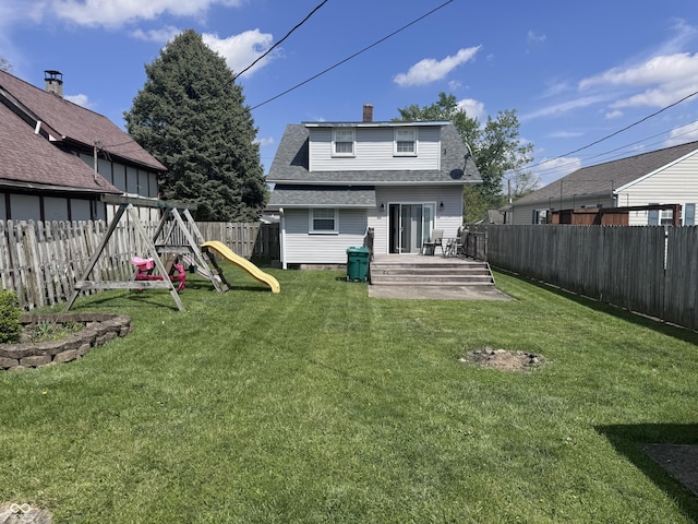back of house with a playground, a shingled roof, a wooden deck, and a chimney