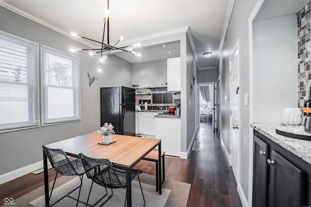 2407 N Capitol Ave, Indianapolis, IN 46208 - dining room featuring ornamental molding, a chandelier, dark wood-type flooring, and baseboards