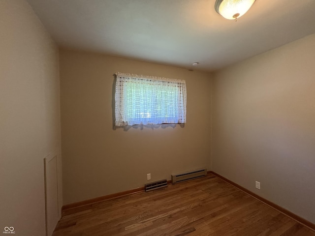 1314 E Orange Pike, Rushville, IN 46173 - spare room featuring a baseboard heating unit and wood finished floors
