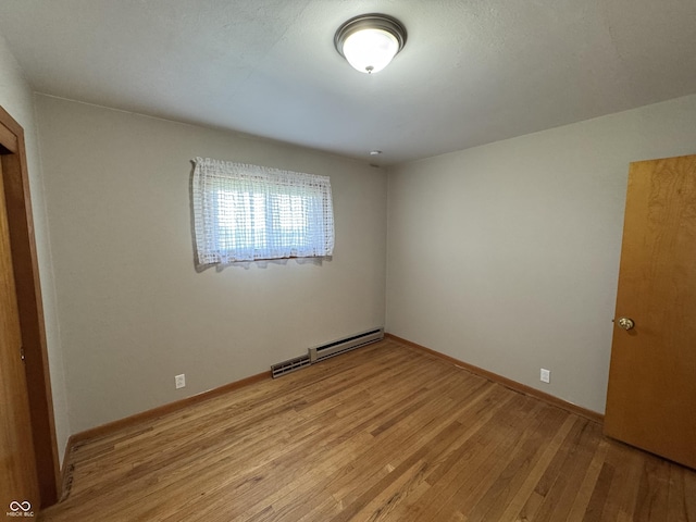1314 E Orange Pike, Rushville, IN 46173 - unfurnished bedroom with a baseboard radiator and light wood-type flooring