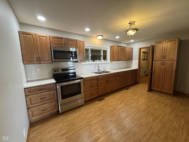 1314 E Orange Pike, Rushville, IN 46173 - kitchen with stainless steel appliances, light wood-style floors, backsplash, and recessed lighting
