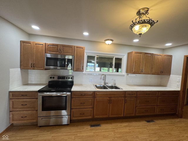 1314 E Orange Pike, Rushville, IN 46173 - kitchen featuring stainless steel appliances, light wood-style floors, light countertops, brown cabinetry, and recessed lighting