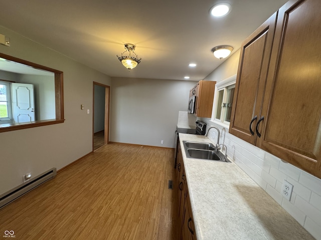 1314 E Orange Pike, Rushville, IN 46173 - kitchen with a baseboard heating unit, stainless steel microwave, tasteful backsplash, light wood finished floors, and light countertops