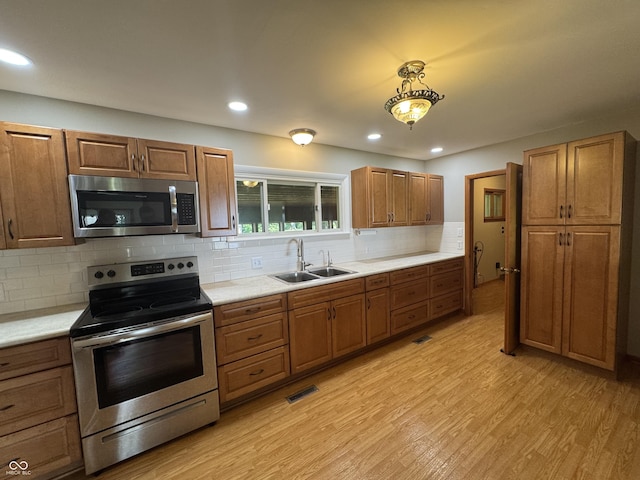 1314 E Orange Pike, Rushville, IN 46173 - kitchen featuring appliances with stainless steel finishes, light countertops, light wood-style floors, tasteful backsplash, and recessed lighting