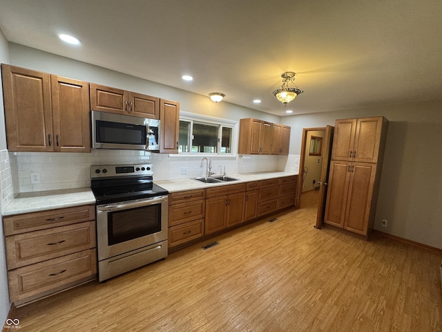 1314 E Orange Pike, Rushville, IN 46173 - kitchen featuring appliances with stainless steel finishes, light wood-type flooring, light countertops, decorative backsplash, and recessed lighting
