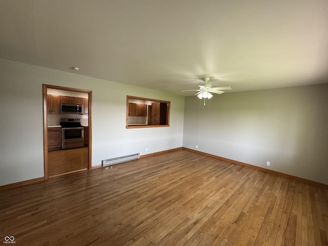 1314 E Orange Pike, Rushville, IN 46173 - spare room with baseboard heating, wood finished floors, and a ceiling fan