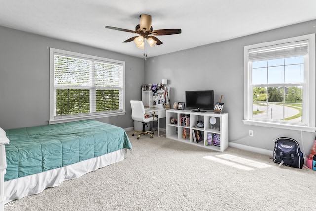 bedroom featuring multiple windows, carpet floors, baseboards, and a ceiling fan