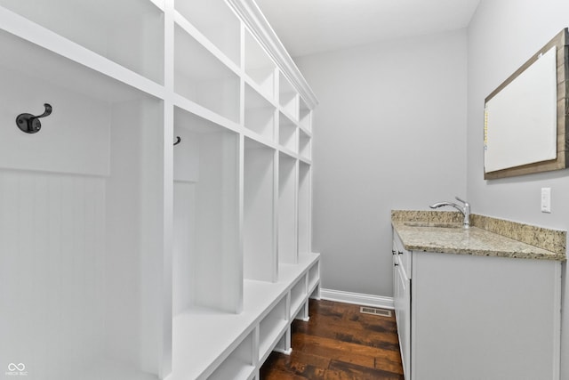 mudroom with a sink, dark wood-style flooring, and baseboards