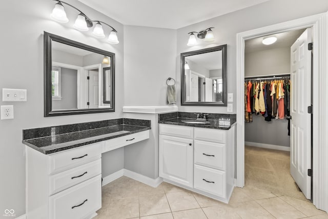 full bath with vanity, tile patterned flooring, a spacious closet, and baseboards