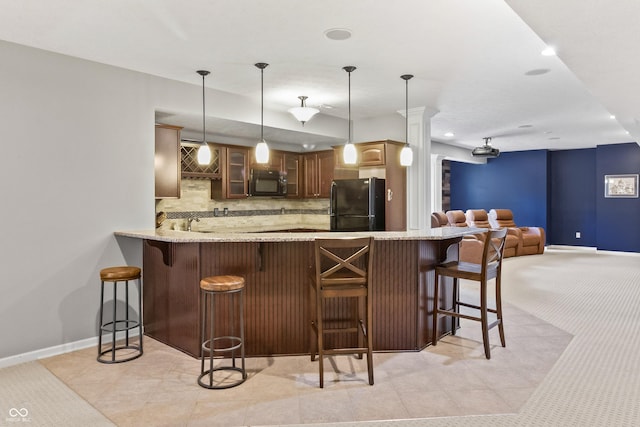 kitchen featuring black appliances, a peninsula, glass insert cabinets, tasteful backsplash, and baseboards