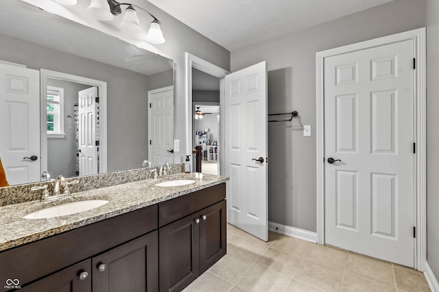 full bathroom with double vanity, baseboards, tile patterned floors, and a ceiling fan