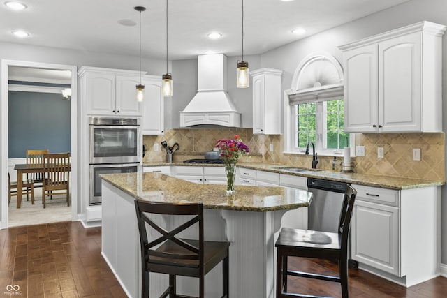 kitchen with stainless steel appliances, custom exhaust hood, a sink, dark wood-type flooring, and recessed lighting