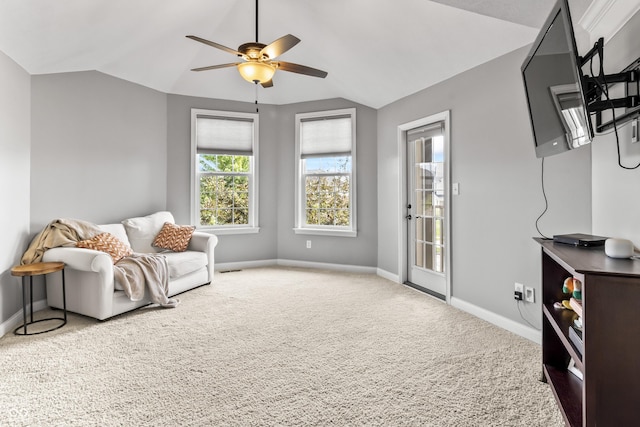 living area featuring lofted ceiling, baseboards, ceiling fan, and carpet flooring