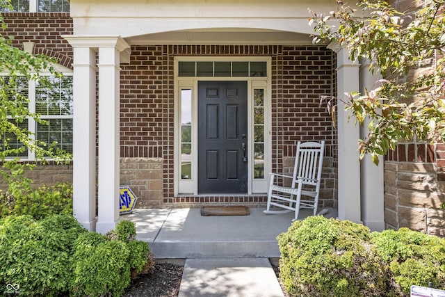 property entrance with brick siding and covered porch