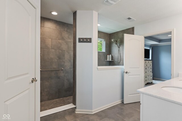 bathroom with a walk in shower, baseboards, tile patterned floors, vanity, and recessed lighting