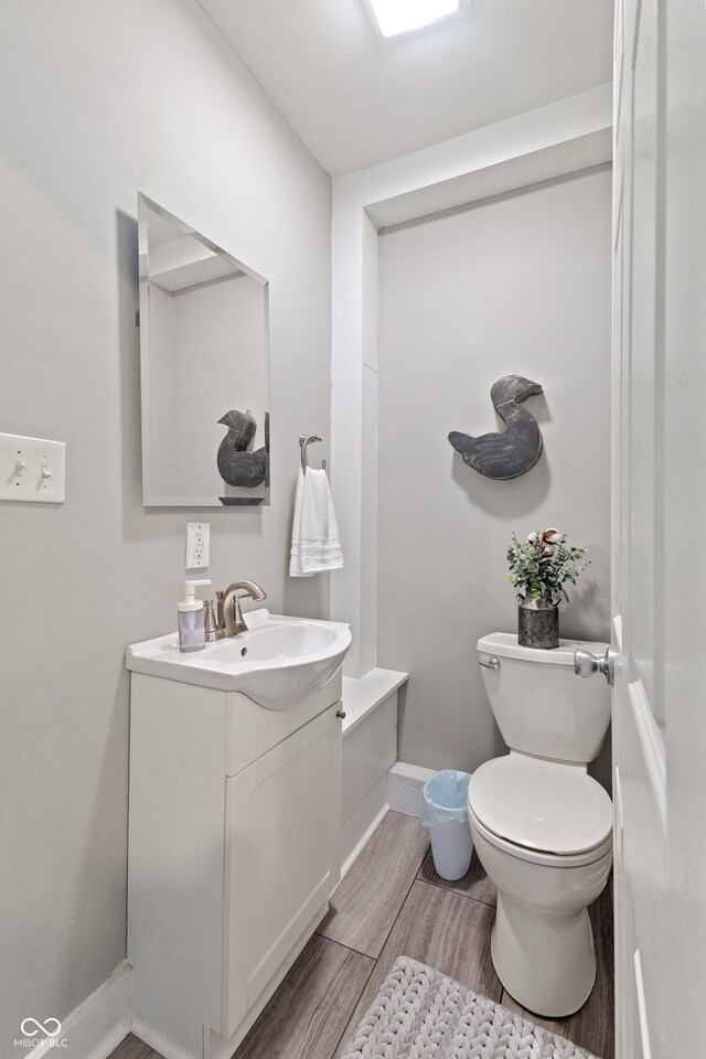 923 S State Ave, Indianapolis, IN 46203 - bathroom featuring wood finished floors, toilet, vanity, and baseboards