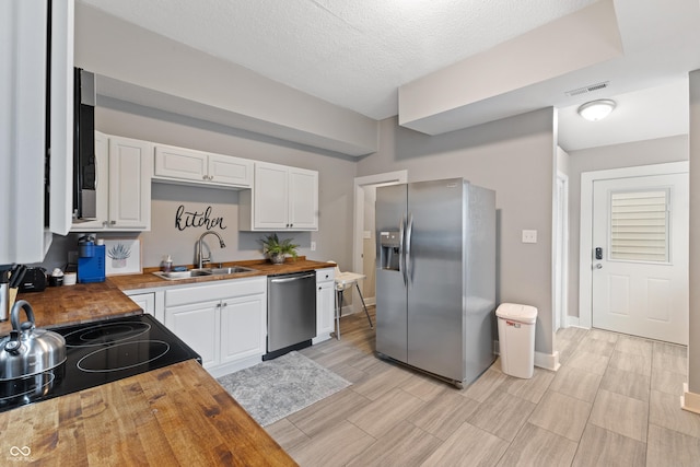 923 S State Ave, Indianapolis, IN 46203 - kitchen featuring stainless steel appliances, a sink, wood counters, white cabinetry, and light wood-style floors