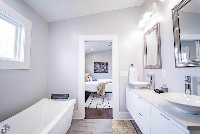 1112 Spann Ave, Indianapolis, IN 46203 - full bath with wood finished floors, a freestanding tub, ensuite bathroom, double vanity, and baseboards