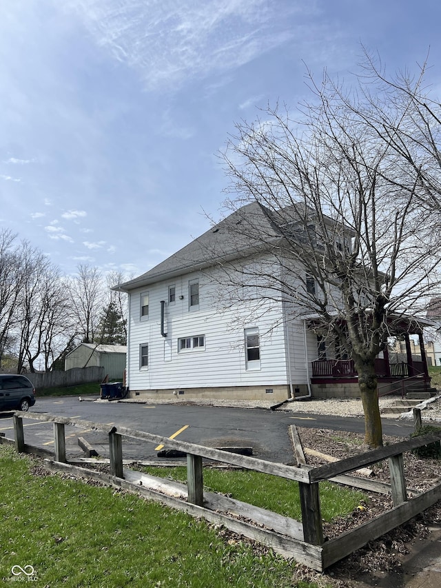 view of side of home with fence and crawl space