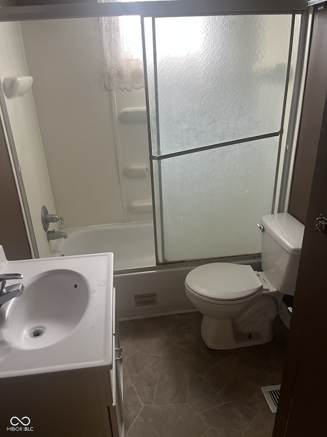 bathroom featuring toilet, vanity, shower / bath combination with glass door, and tile patterned floors