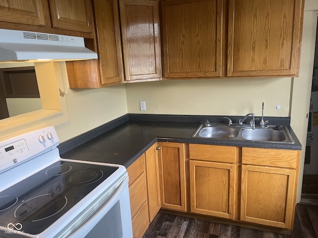 kitchen featuring white electric range oven, under cabinet range hood, a sink, dark wood finished floors, and dark countertops
