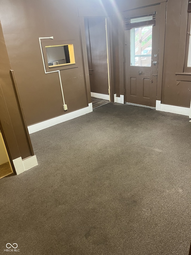 unfurnished room with carpet flooring and baseboards