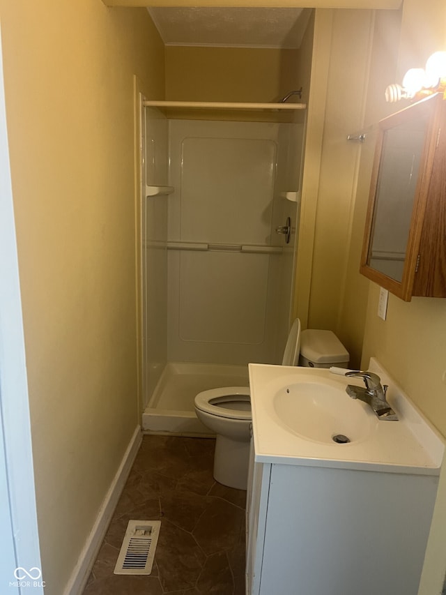 full bathroom with toilet, a shower stall, vanity, and baseboards