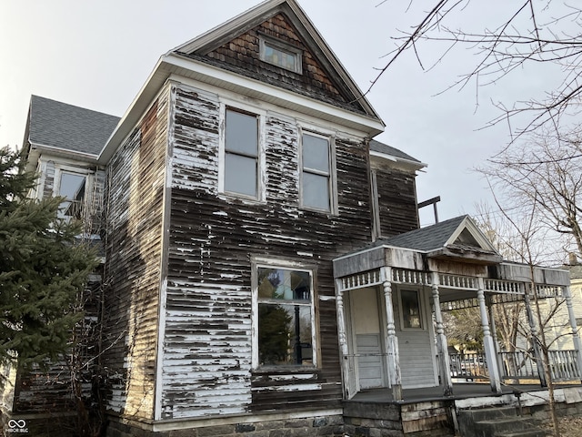 view of front of property featuring covered porch and roof with shingles