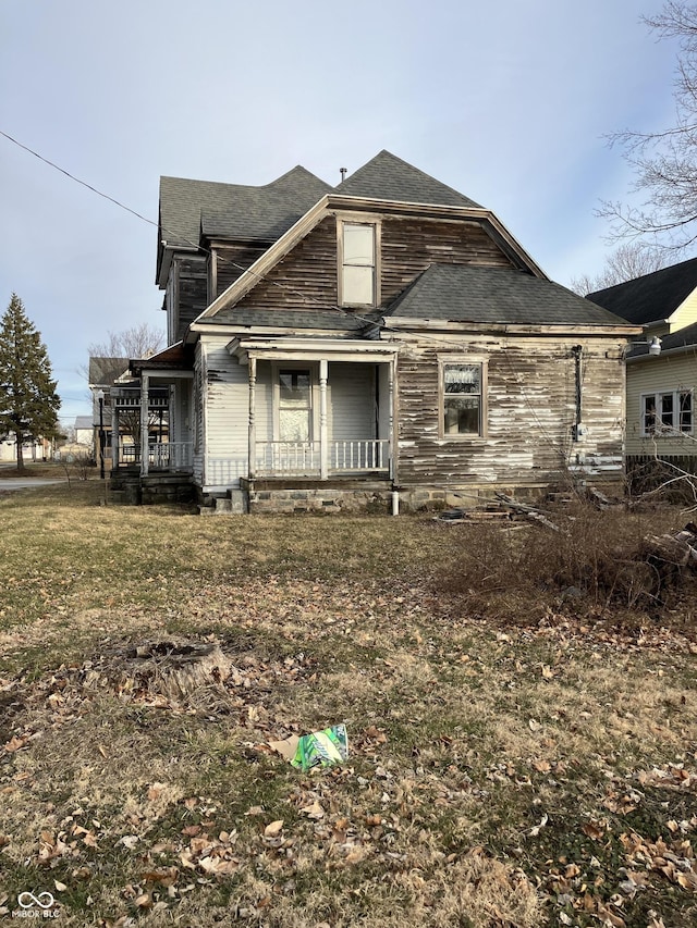 view of property exterior with roof with shingles and covered porch