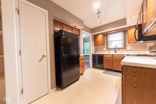980 Red Maple Ct, Greenwood, IN 46143 - kitchen featuring a sink, light countertops, black appliances, and brown cabinets