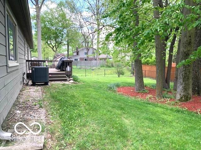 view of yard featuring central AC unit, a deck, and a fenced backyard