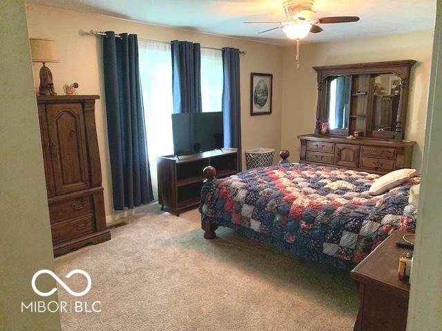 bedroom with ceiling fan and light colored carpet