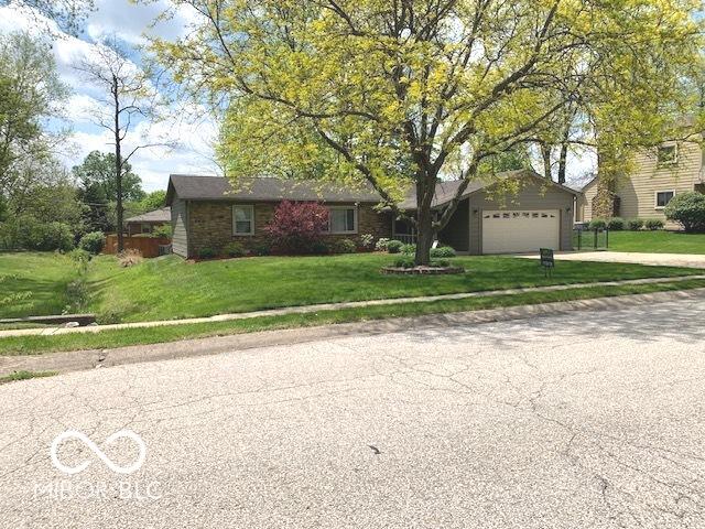 ranch-style home with concrete driveway, a garage, and a front yard