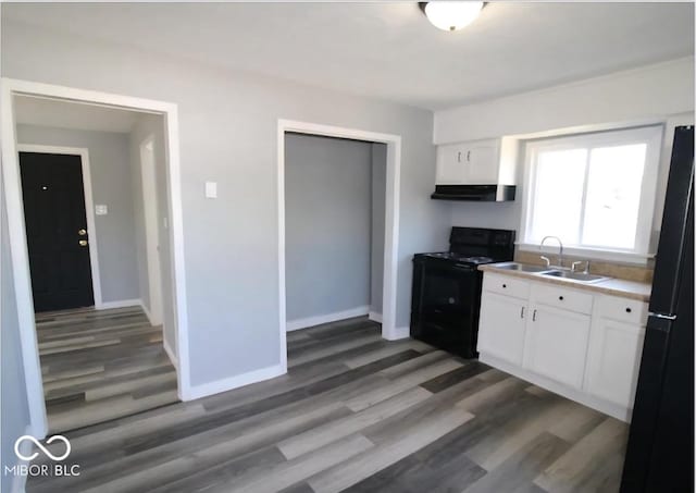 kitchen with white cabinetry, black electric range oven, a sink, and under cabinet range hood