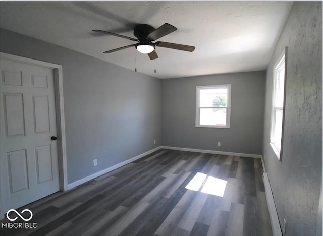 unfurnished room with dark wood-type flooring, baseboards, and ceiling fan