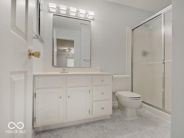 bathroom with toilet, a shower stall, and vanity