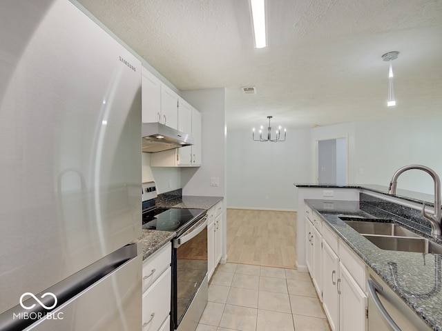 kitchen with appliances with stainless steel finishes, under cabinet range hood, a sink, white cabinetry, and a chandelier