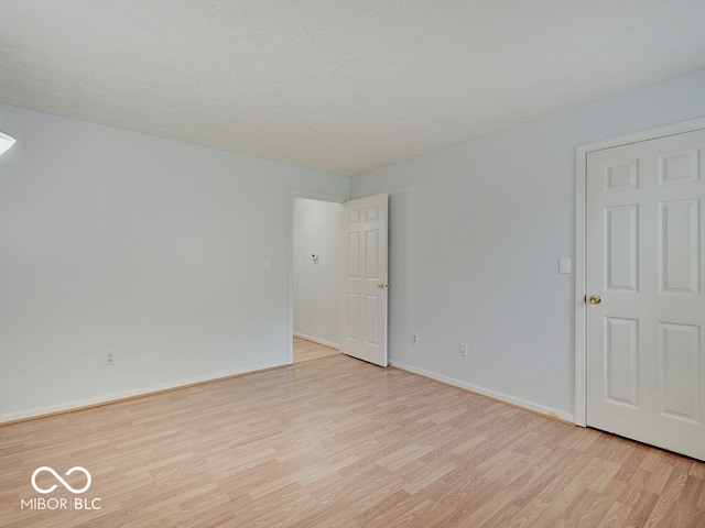 empty room featuring light wood-type flooring and baseboards