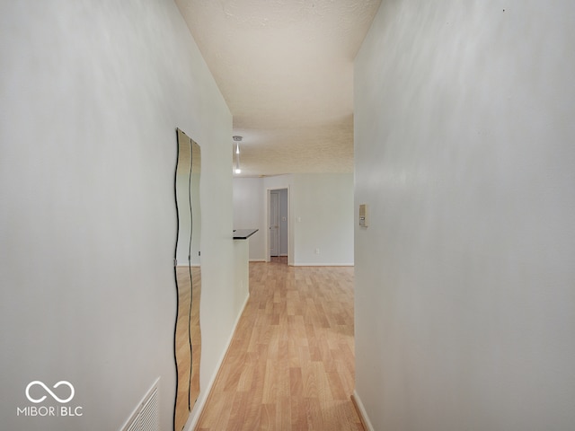 hallway with light wood-style floors and baseboards