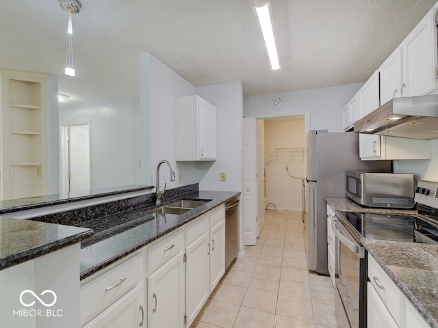 kitchen with stainless steel appliances, a sink, under cabinet range hood, white cabinets, and a textured ceiling
