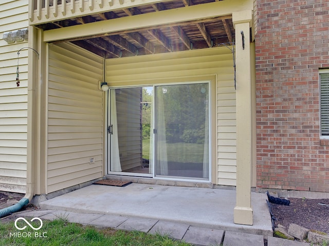 view of exterior entry with brick siding