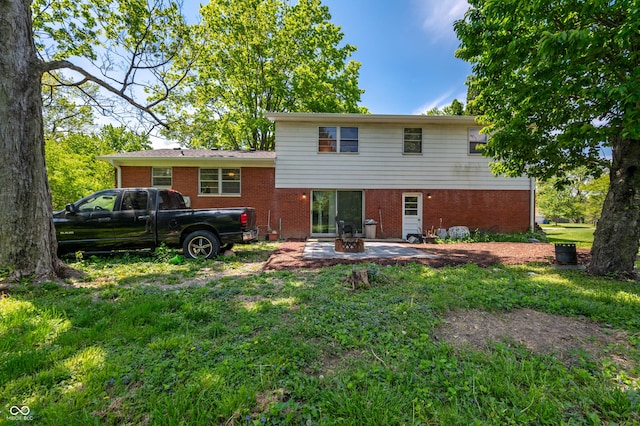 rear view of house with a patio, brick siding, and a lawn