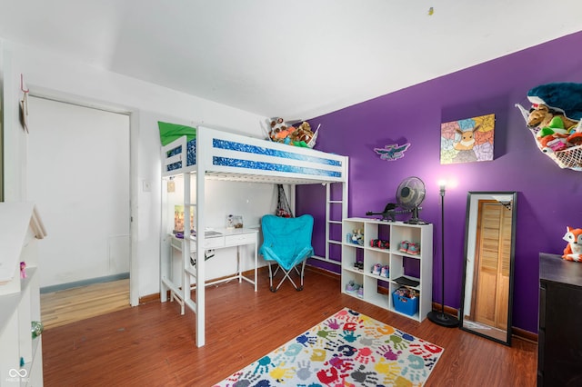 bedroom featuring wood finished floors and baseboards