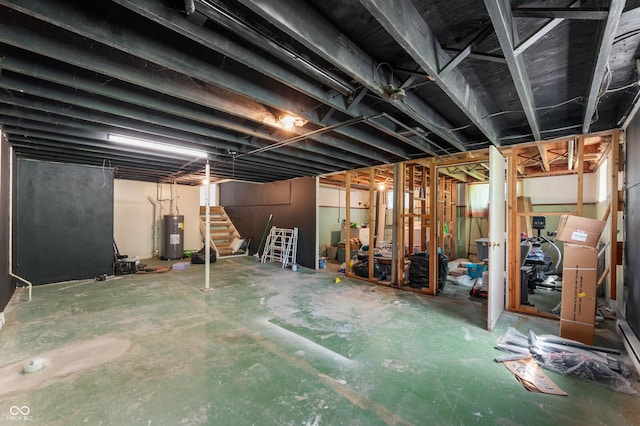 unfinished basement featuring stairway and water heater