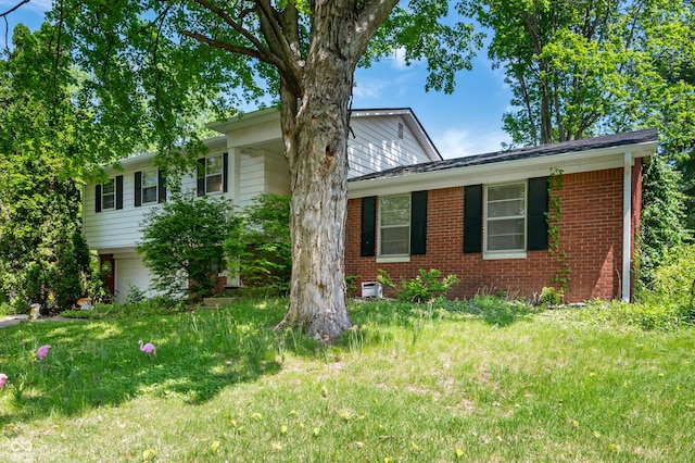 view of front of home with brick siding, a front yard, and an attached garage