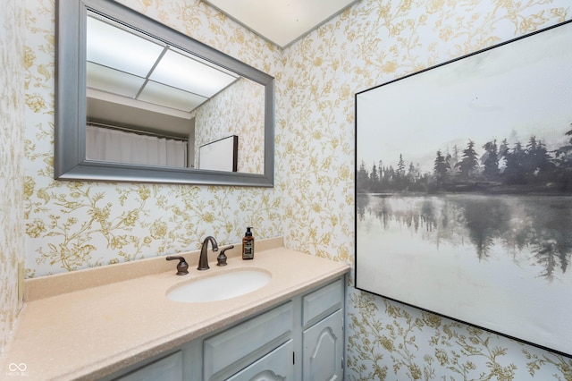 bathroom with wallpapered walls and vanity