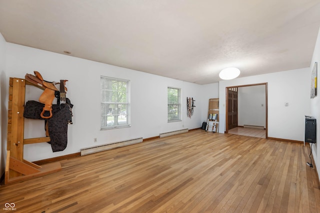 unfurnished living room with a baseboard radiator, a baseboard heating unit, light wood-style flooring, and baseboards