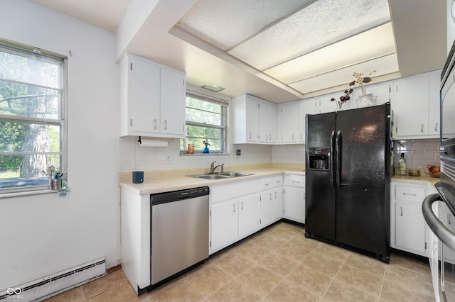 kitchen featuring black fridge, dishwasher, baseboard heating, a sink, and light countertops