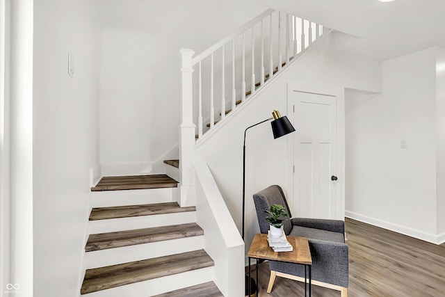 stairway featuring wood finished floors and baseboards