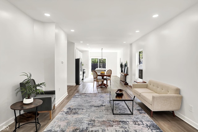 living room featuring wood finished floors, recessed lighting, and baseboards
